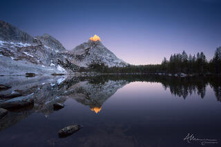 The sunrise hitting the top of Ragged peak is reflected in Young Lake in the Yosemite backcountry.