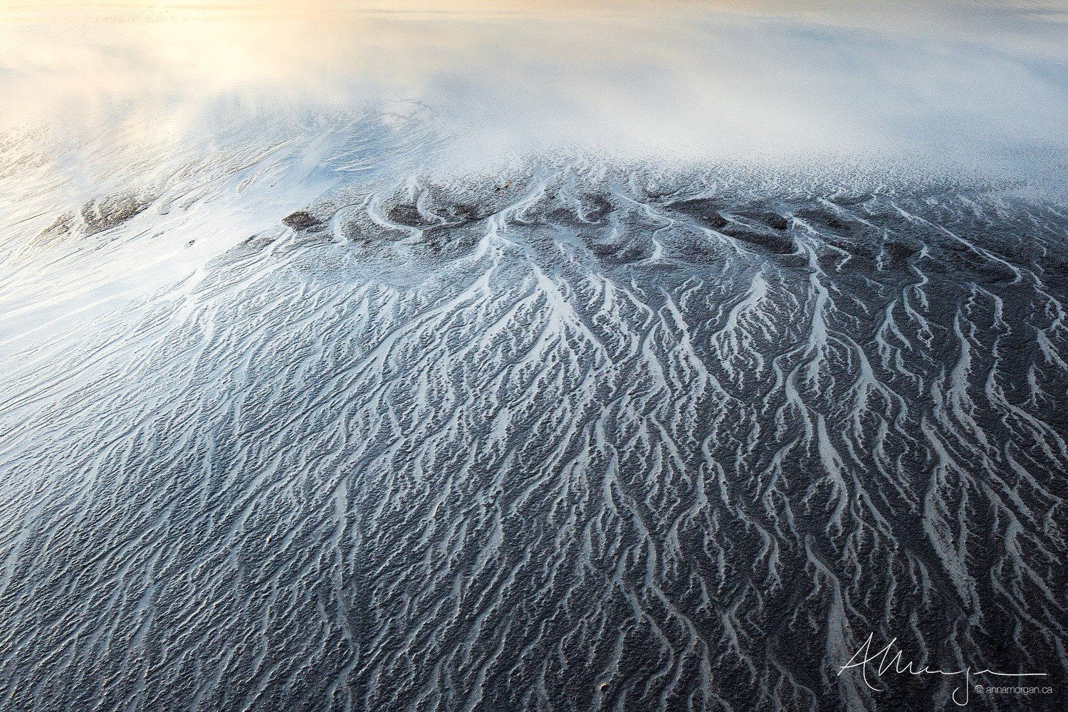 Sand Etching Black and white sand on a Norwegian beach form patterns that look like running ink
